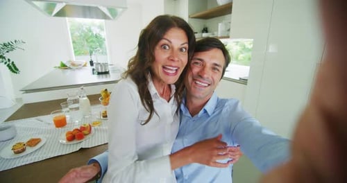 A happy couple is making a selfie or video technology call to their relatives or friends while hav