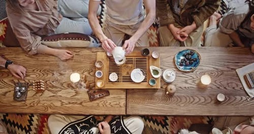 Anonymous Friends During Tea Ceremony Top View of Crop Man Brewing Tea on Table During Meeting with