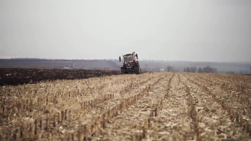 Red tractor plowing the field in Ukraine