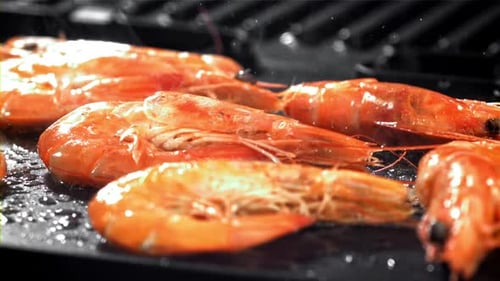 Die Garnelen werden in einer Pfanne gebraten, wobei ein Spritzer mit einer Hochgeschwindigkeitskamera mit 1000 Bildern pro Sekunde gefilmt wurde