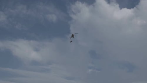 Hélicoptère volant pour aller chercher de l'eau avec le seau pour éteindre l'incendie estival en Italie, en Calabre