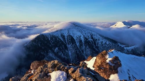 Low Inversion Clouds Drift Over Snowcapped Mountain Peaks and Hills in the Valley Below Showcasing