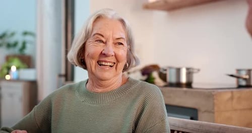 Senior Woman Laughing and Drinking from Cup at Home