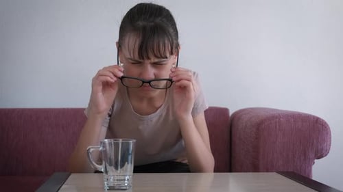 Teen Girl Taking Off Glasses Indoors