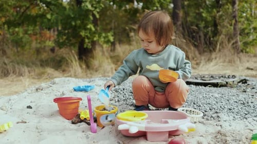 Cute Child Playing with Toys in a Sandpit