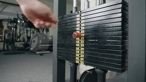 Adjusting Weight on Gym Equipment During Workout Session