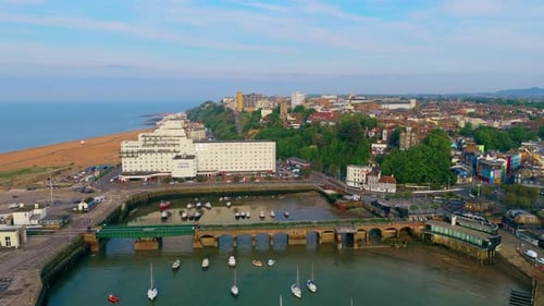 Panning over calm picturesque Folkestone harbour with mooring boats
