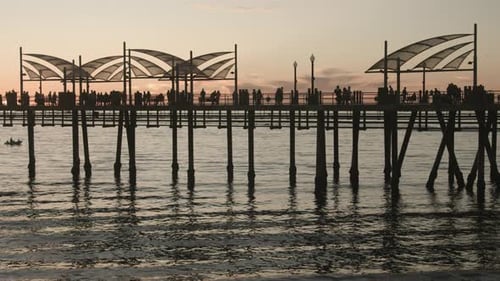 Cinematic footage of the Redondo Beach Pier at sunset with ocean waves, fishing, and vibrant