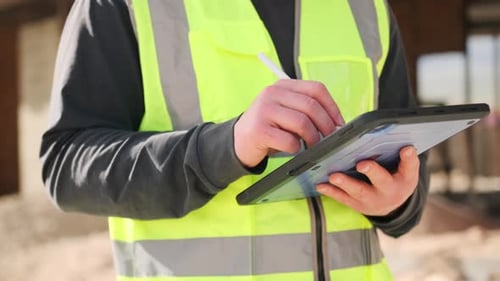 Close up tablet in hands unknown architect engineer, browsing building project blueprint plan