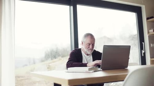 Senior man using laptop at table