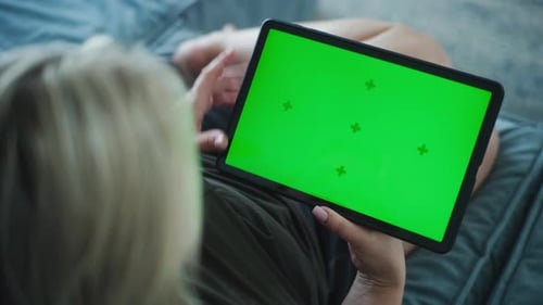 Woman Using Tablet with Green Screen Lying on Couch