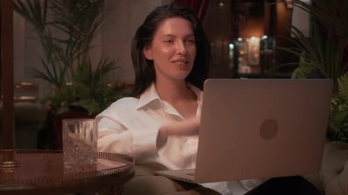 Businesswoman Using Laptop on Couch in Elegant Hotel Lounge