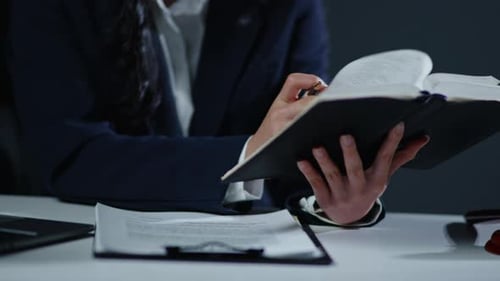 Close up of gavel hammer and lawyer's hands is reading a book table in the office.