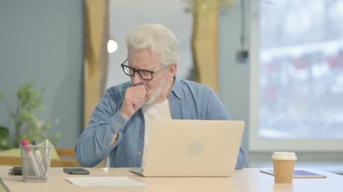 Adult Coughing While Working at a Laptop