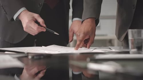 Businessmen Discussing Paperwork in Office Setting