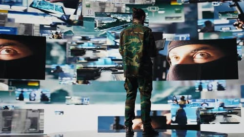 Man in Camouflage Works with Laptop in Futuristic Setting