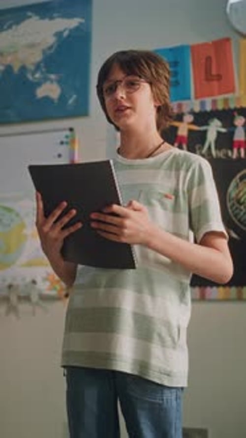 Niño de escuela primaria con cuaderno hablando haciendo una presentación sobre ecología