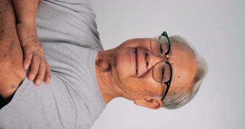 Vertical clip. Close up, portrait of older man smiling and looking at the camera