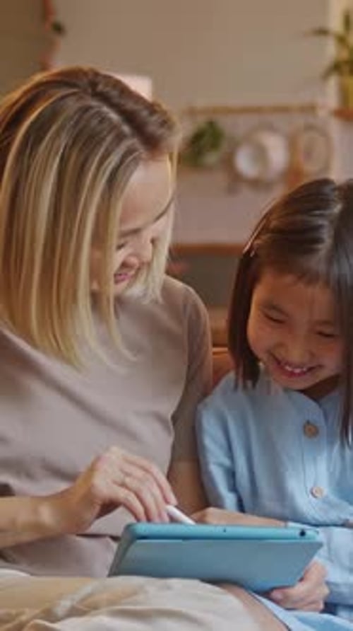 Smiling Woman and Child Using Tablet Indoors