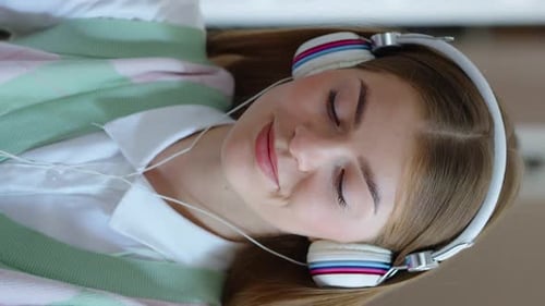Vertical Screen Student Doing Homework and Listening to Music with Headphones