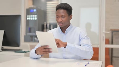 African Businessman Using Digital Tablet in Office
