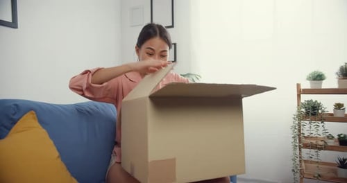 Excited Woman Opening Delivery Box at Home