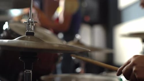 Drummer and band at concert, close up view of drum plate