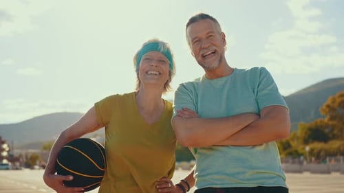 Smiling Senior Couple with Basketball Outside on Sunny Day