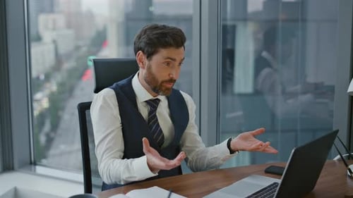 Cheerful bearded consultant talking with clients on online meeting in modern office