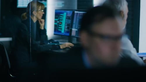 Team von technischen Spezialisten, die an ihren Arbeitsplätzen im System Con an PCs arbeiten