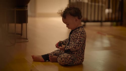 Infant Sitting on Floor Playing with Toy Car