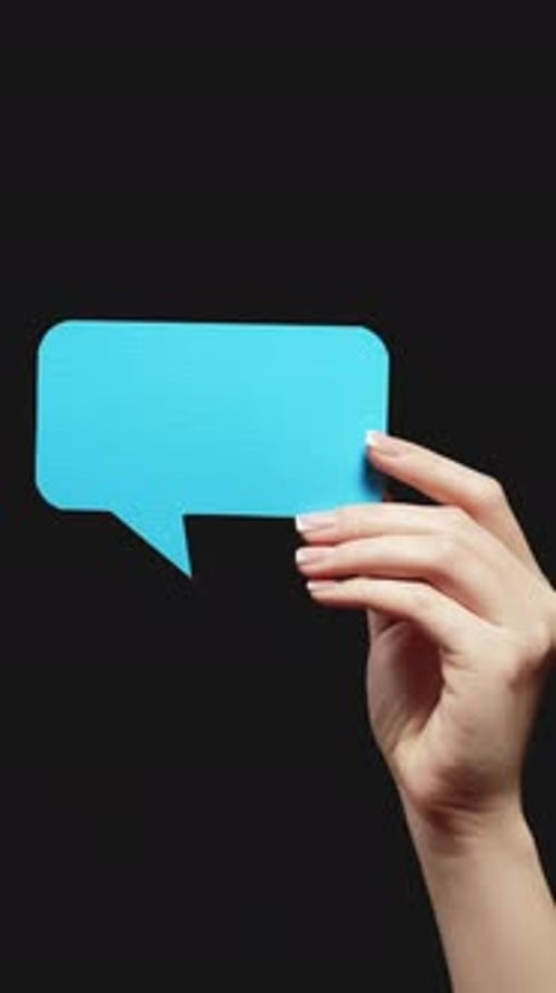 Hand Holding Blue Speech Bubble on Black