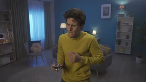 The Man is Bent Over Holding His Hand on His Stomach Suffering From Pain Close Up A Man Takes a Pill