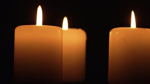 Glowing Candles Burning in the Dark