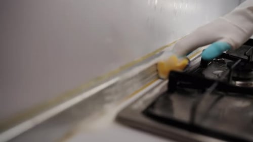 Hand Cleaning Kitchen Cooktop with Sponge