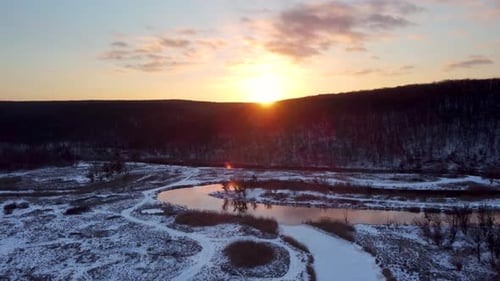 Aerial sunset sun shine above wintry river valley