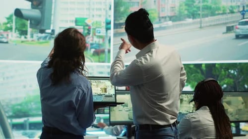 Vielfältiges Team verfolgt den Stadtverkehr auf einem Display im Überwachungsraum