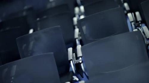 Rows of Empty Dark Blue Seats in a Quiet Auditorium Shallow Depth of Field Showing Repeating