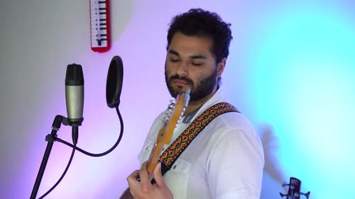musician concentrating on the chords of his guitar. musician with guitar playing music in studio