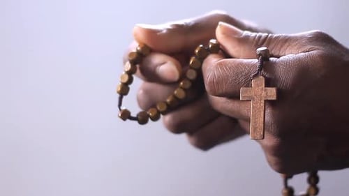 Wooden Rosary Beads Held in Hands With Cross