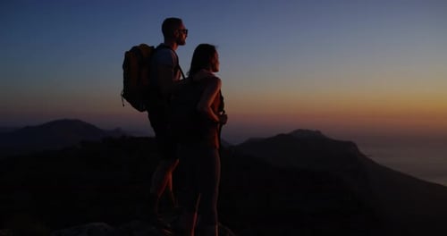 Couple, hiking and mountain top for adventure, night and outdoor over ocean