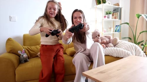 Mother and Daughter Playing Video Games on Couch