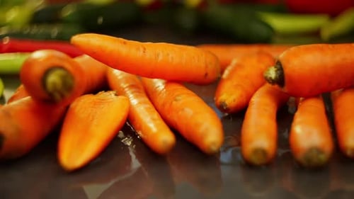 Slow Motion Video of Carrots Falling on a Dark Surface