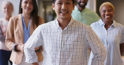 Smiling diverse business team standing together in modern office environment