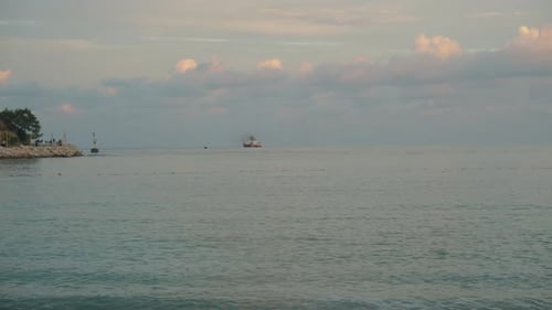 Panorama der Bucht im Meer zwischen zwei Felsen, ein Schiff in der Ferne bei Sonnenuntergang. Hohe Klippen.