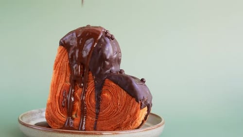 Dark Chocolate Fall Into Heart Shaped Dark Chocolate Croissant on Pastel Green Background Puff