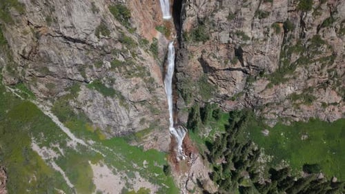 Waterfall Cascading Down Rocky Mountainside in Scenic Landscape