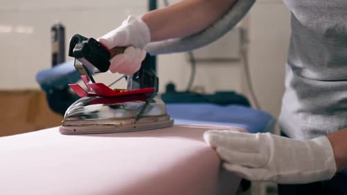 Close Up Professional Dry Cleaning Young Girl Ironing Pink with a Professional Iron with Steam