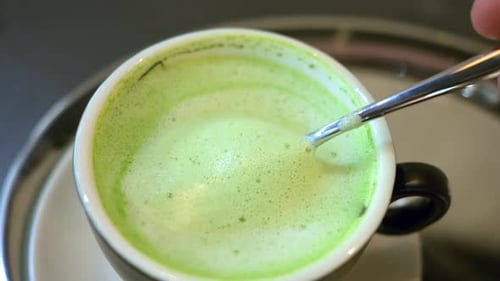 Close up green matcha latte drink on a cup