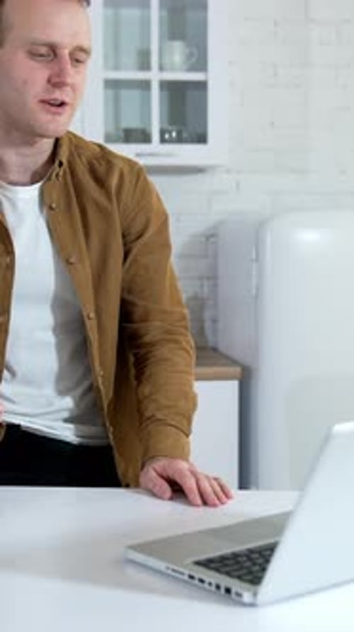 Young man freelancer using laptop. Businessman working on laptop from home office. Vertical video